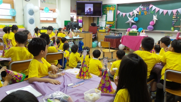 지난 6월 8일 철산초등학교 1학년 교실에서 백일잔치가 열린 가운데 학생들이 선생님과 학부모들이 만든 동영상을 보고 있다./사진 철산초등학교 제공